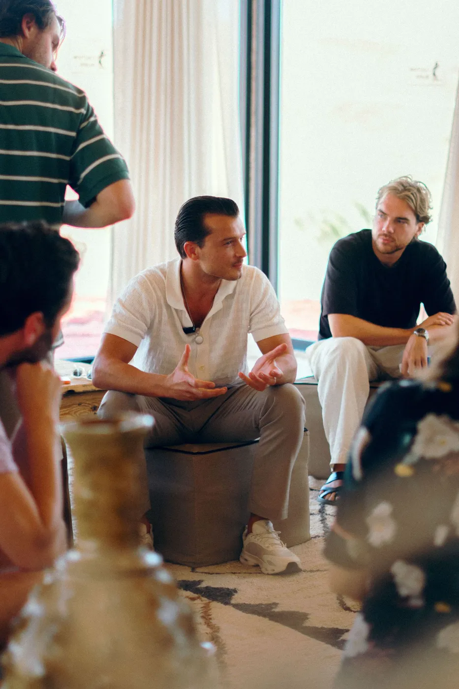 Een founder legt met beide handen een idee uit in een kleine gespreksgroep.