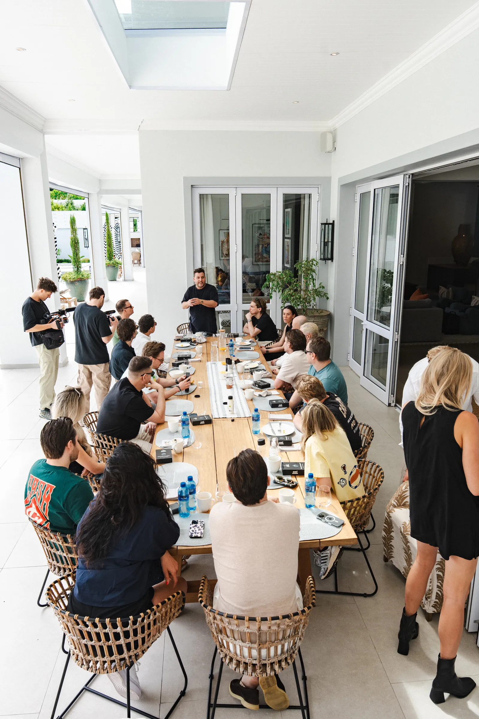 De founders en builders overleggen aan de lange tafel op het terras.